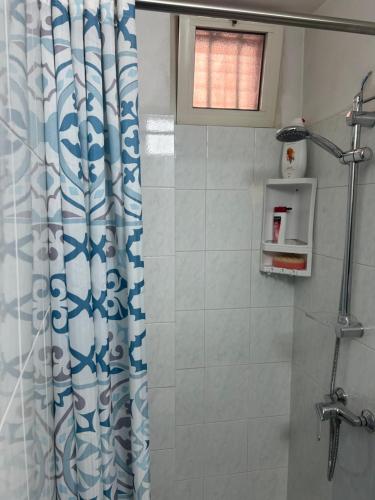 a shower with a blue and white shower curtain at Camine Home in Aradeo