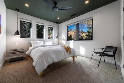 a bedroom with a bed and a chair and windows at LaFave Luxury Rentals at Zion in Springdale