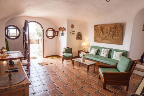 ein Wohnzimmer mit einem grünen Sofa und Stühlen in der Unterkunft Ferienhaus für 2 Personen  1 Kind ca 70 m in Santa Brígida, Gran Canaria Binnenland Gran Canaria in Santa Brígida