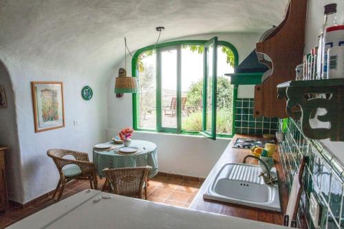 eine Küche mit einem Tisch, einem Waschbecken und einem Fenster in der Unterkunft Ferienhaus für 2 Personen  1 Kind ca 70 m in Santa Brígida, Gran Canaria Binnenland Gran Canaria in Santa Brígida