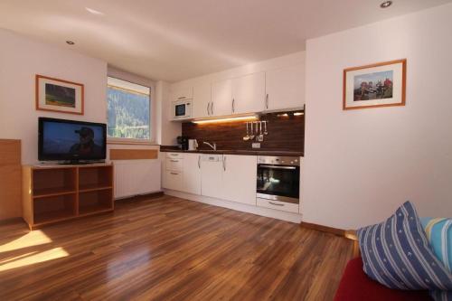 a large kitchen with white cabinets and a tv in it at Wohnung in Kappl mit Eigenem Balkon in Kappl