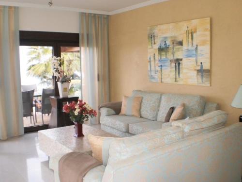 uma sala de estar com um sofá e uma mesa em Ferienhaus mit hellem Wohnbereich, zwei Schlafzimmern und einer Terrasse em Guía de Isora