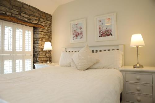 a bedroom with a white bed and two lamps at The Cosy Cottage Retreat! Perfect for Contractors, Relocators, Getaway in Llantrisant