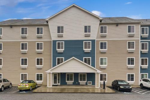 a large building with cars parked in a parking lot at WoodSpring Suites Macon West I-475 in Macon