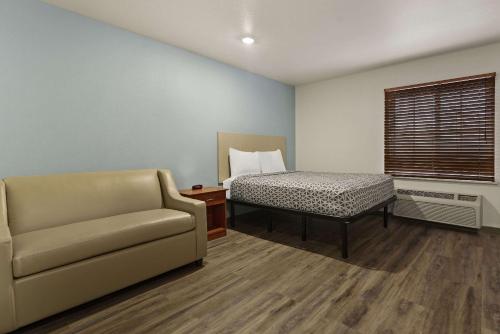 a living room with a couch and a bed at WoodSpring Suites Macon West I-475 in Macon