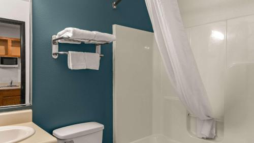 y baño con ducha, aseo y lavamanos. en WoodSpring Suites Evansville, en Evansville