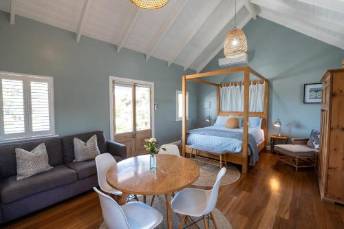 a living room with a couch and a table and a bed at Beach Huts Middleton in Middleton