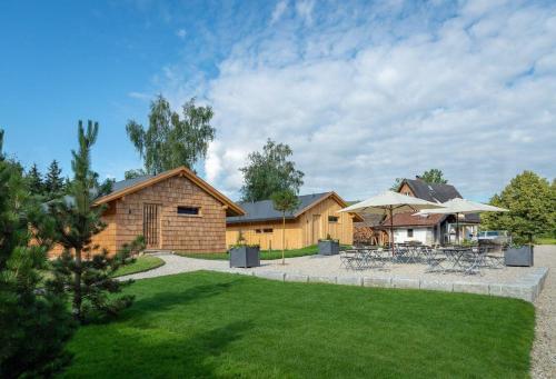 una casa con un patio con mesas y sombrillas en Ferienhaus für 2 Personen ca 87 qm in Regen-Kattersdorf, Bayern Bayerischer Wald - b57260, en Regen