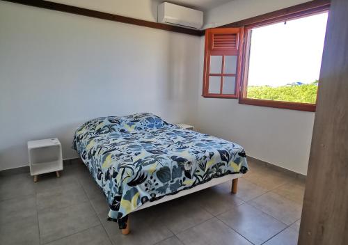 a bedroom with a bed in a room with a window at Villa - 3 chambres climatisées - proche plages Nord Grande-Terre in Anse-Bertrand