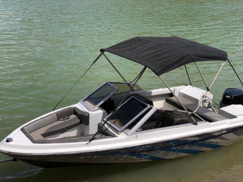 a white boat with an umbrella on the water at Tree House, Cabaña privada con Jacuzzi in Guatapé