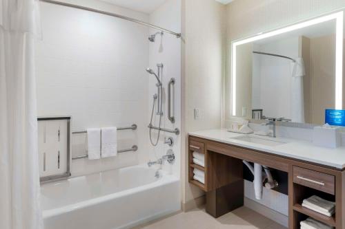 Home2 Suites By Hilton Redlands في ريدلاندز: حمام مع حوض ومغسلة ودش