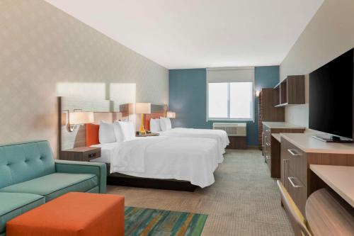 Home2 Suites By Hilton Redlands في ريدلاندز: غرفه فندقيه سرير وتلفزيون