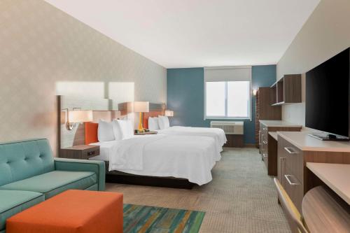 雷德兰兹Home2 Suites By Hilton Redlands的配有床和电视的酒店房间