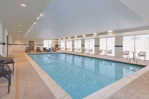 una grande piscina con sedie in una camera d'albergo di Home2 Suites By Hilton Clovis a Clovis