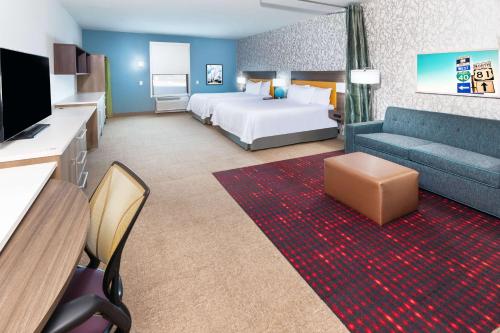 a hotel room with a bed and a couch at Home2 Suites By Hilton Weatherford in Weatherford
