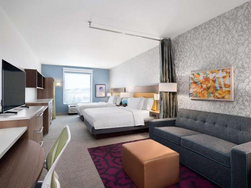 Habitación de hotel con cama y sofá en Home2 Suites By Hilton Round Rock Medical Center en Round Rock
