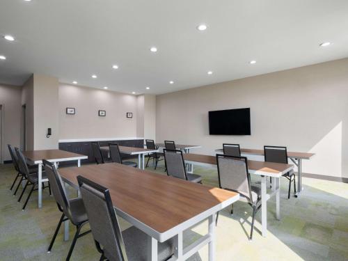 a conference room with tables and chairs and a flat screen tv at Home2 Suites By Hilton Round Rock Medical Center in Round Rock