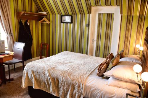 a bedroom with a bed in a room with green stripes at The Hotel Commodore in Llandrindod Wells