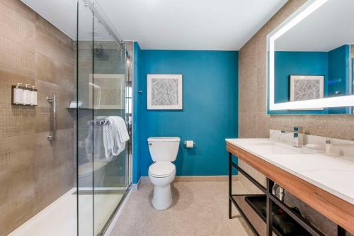 uma casa de banho com um WC e uma cabina de duche em vidro. em Cambria Hotel Nashville Midtown em Nashville