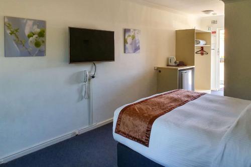パースにあるEcono Lodge Rivervaleのベッドルーム(ベッド1台、薄型テレビ付)