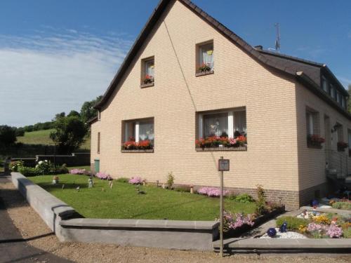 uma casa com flores nas janelas em Ferienwohnung für 4 Personen ca 80 qm in Niederehe, Rheinland-Pfalz Naturpark Vulkaneifel em Niederehe