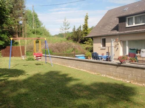 einen Hof mit einer Schaukel und einem Haus in der Unterkunft Ferienwohnung für 4 Personen ca 80 m in Niederehe, Rheinland-Pfalz Naturpark Vulkaneifel in Niederehe