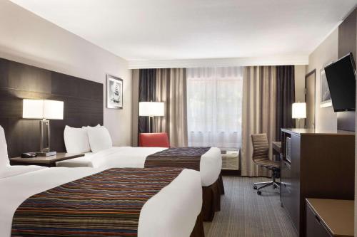 um quarto de hotel com duas camas e uma televisão em Country Inn & Suites by Radisson, Lackland AFB San Antonio , TX em San Antonio