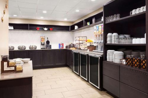 a kitchen with black cabinets and a counter with dishes at Country Inn & Suites by Radisson, Lackland AFB San Antonio, TX in San Antonio
