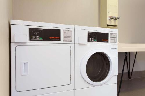 two white washing machines sitting next to each other at Country Inn & Suites by Radisson, Lackland AFB San Antonio, TX in San Antonio