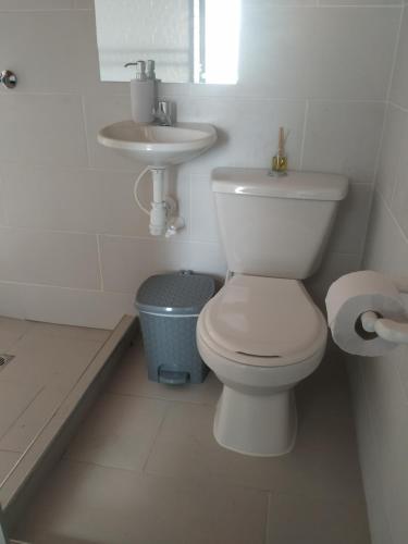 a white bathroom with a toilet and a sink at Hostal El Balcon de madera in Norcasia