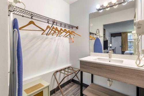 La salle de bains est pourvue d'un lavabo et d'un miroir. dans l'établissement Suburban Studios Tysons Corner, à Vienna