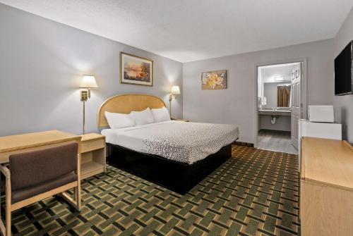een kleine hotelkamer met een bed en een bureau bij Econo Lodge in Clemson