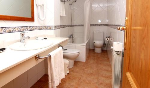 a bathroom with a sink and a toilet and a tub at Hotel Valcarce Camino de Santiago in La Portela de Valcarce