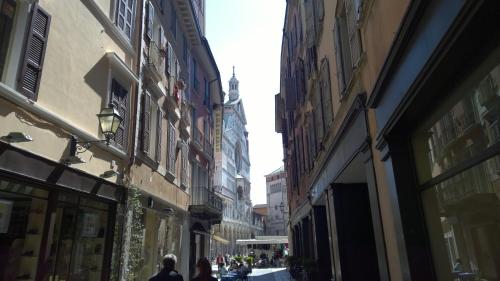 a couple of people walking down a street with buildings at Appartamenti I Liutai in Cremona