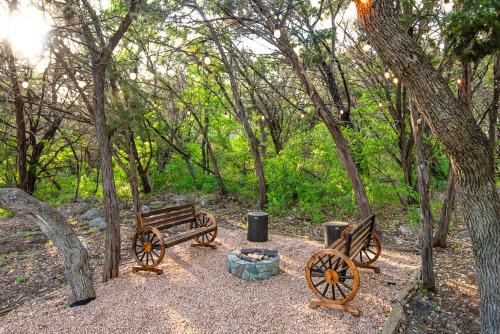 two park benches and a fire pit in a forest at Breathtaking Roof Pool Views, Gameroom, Firepit in San Antonio
