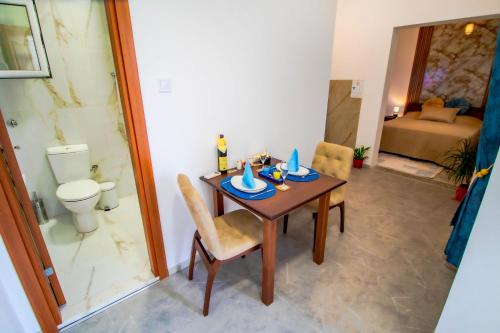 a dining room with a table and a toilet at Simo apartments airport Podgorica in Podgorica