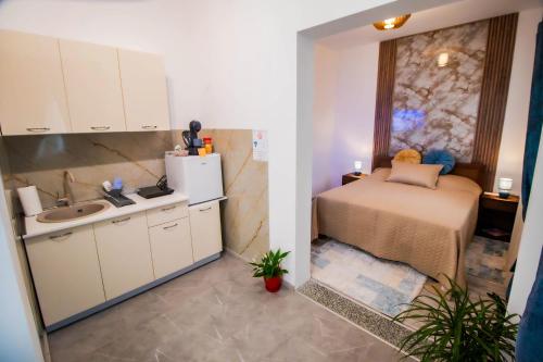 a small kitchen with a bed and a sink at Simo apartments airport Podgorica in Podgorica