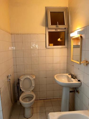 a bathroom with a toilet and a sink at Appartement meublé F4 Maristes, Dakar in Dakar