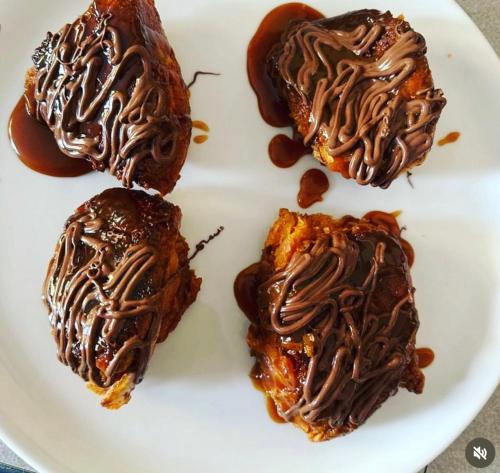 a plate with three chocolate covered pastries on it at ChezBabo Wellness Hotel in Ngaparou