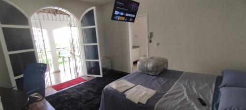 1 dormitorio con 1 cama y TV en la pared en Suíte luxo com sacada mobiliada Q2, en Campinas