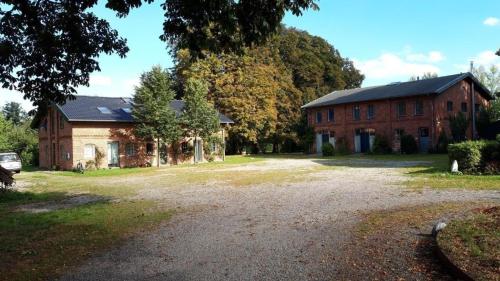 ein großes Backsteinhaus mit großer Auffahrt in der Unterkunft Ferienwohnung 1 auf einem Bioland-Gutshof, in Ostseenähe und direkt am Golfplatz Curau in Stockelsdorf