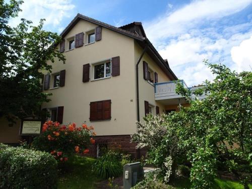 a white house with windows and bushes at Nette Wohnung in Garitz mit Garten, Terrasse und Grill in Bad Kissingen