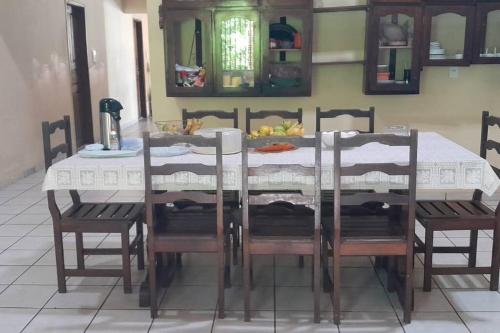 einen Esstisch mit Stühlen und einem weißen Tischtuch in der Unterkunft Casa DOM Santo Amaro do Maranhão in Santo Amaro