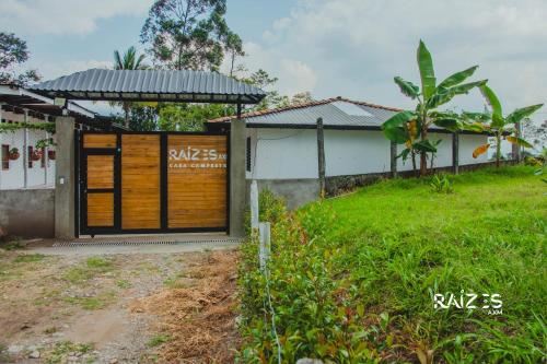 a house with a wooden door in a yard at Raizes AXM I Casa Campestre I Armenia, Quindío, Colombia in Armenia