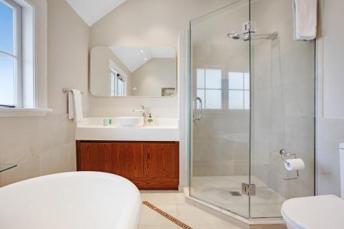 a bathroom with a shower and a sink at Grande Vista 5Br Manor with Pool & Mt Eden Views in Auckland