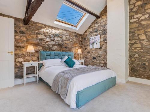 a bedroom with a bed and a stone wall at 2 Bed in Bassenthwaite SZ060 in Uldale