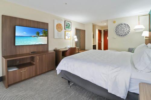 a hotel room with a bed and a flat screen tv at Holiday Inn Quincy by IHG in Quincy