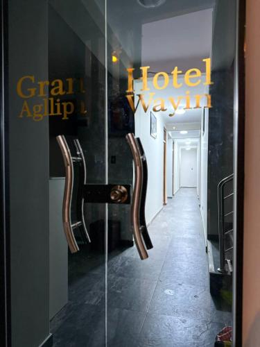 una puerta de cristal con 2 sillas en una habitación de hotel en Gran Hotel, en Yungay