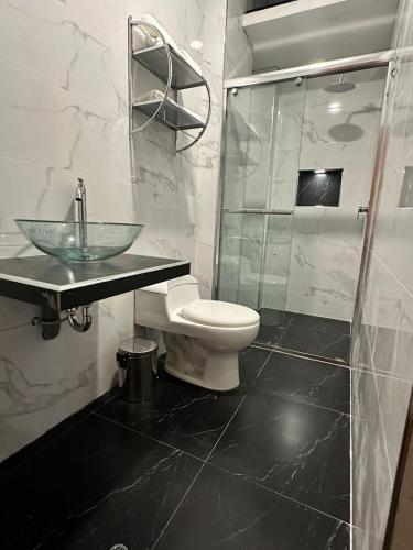 y baño con lavabo, aseo y ducha. en Gran Hotel, en Yungay