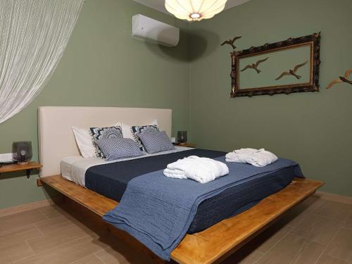 a bedroom with a bed with towels on it at Pasithea Luxury house in Archangelos